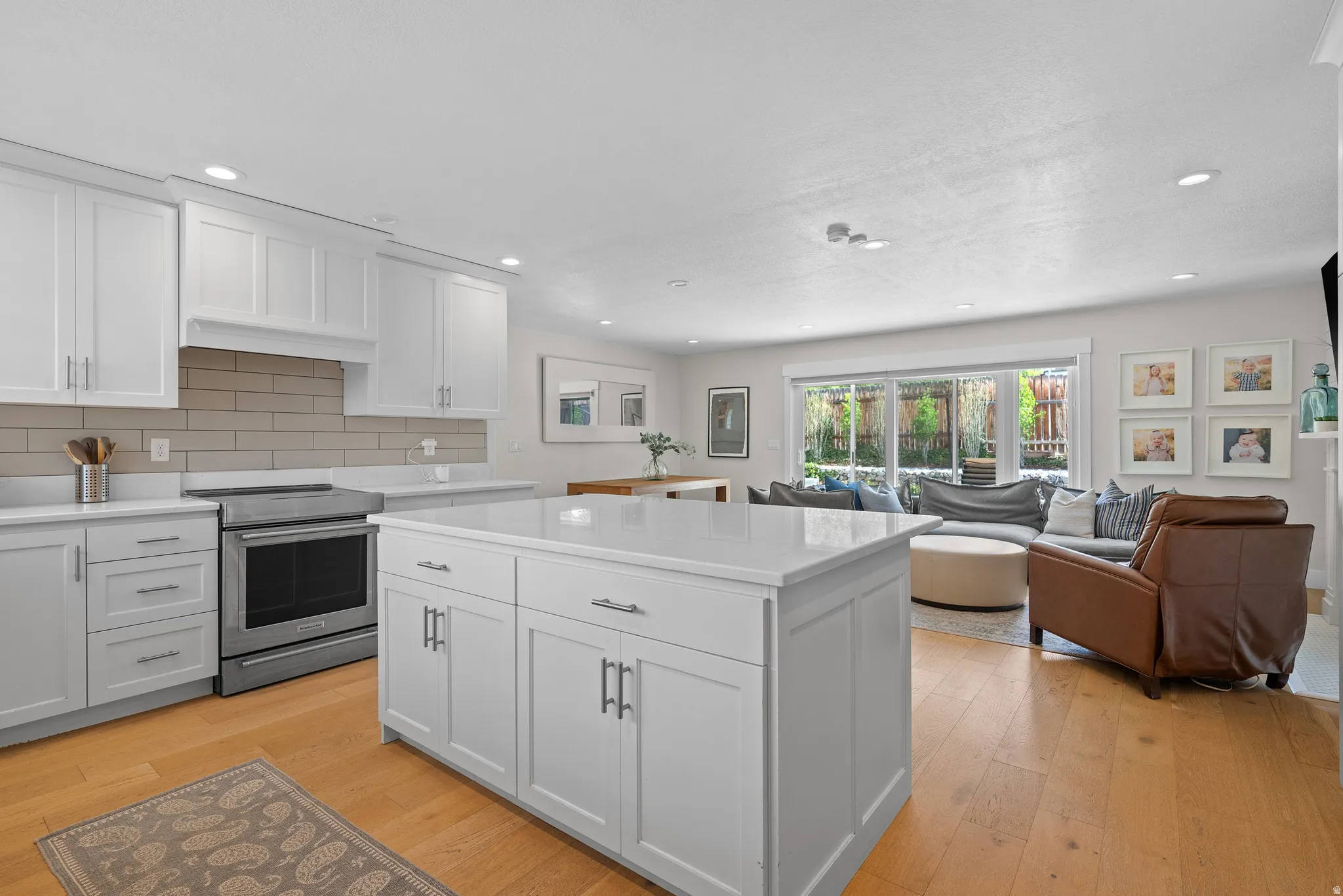 Kitchen featuring white cabinets, electric stove, light wood-style flooring, and recessed lighting