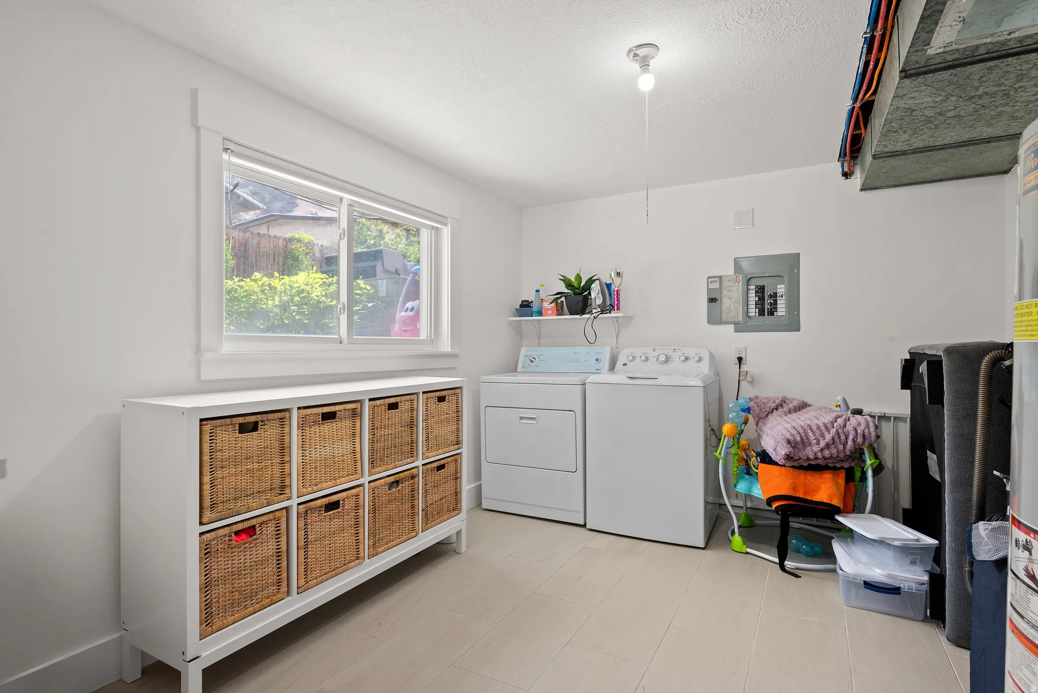 Laundry room with electric panel and separate washer and dryer