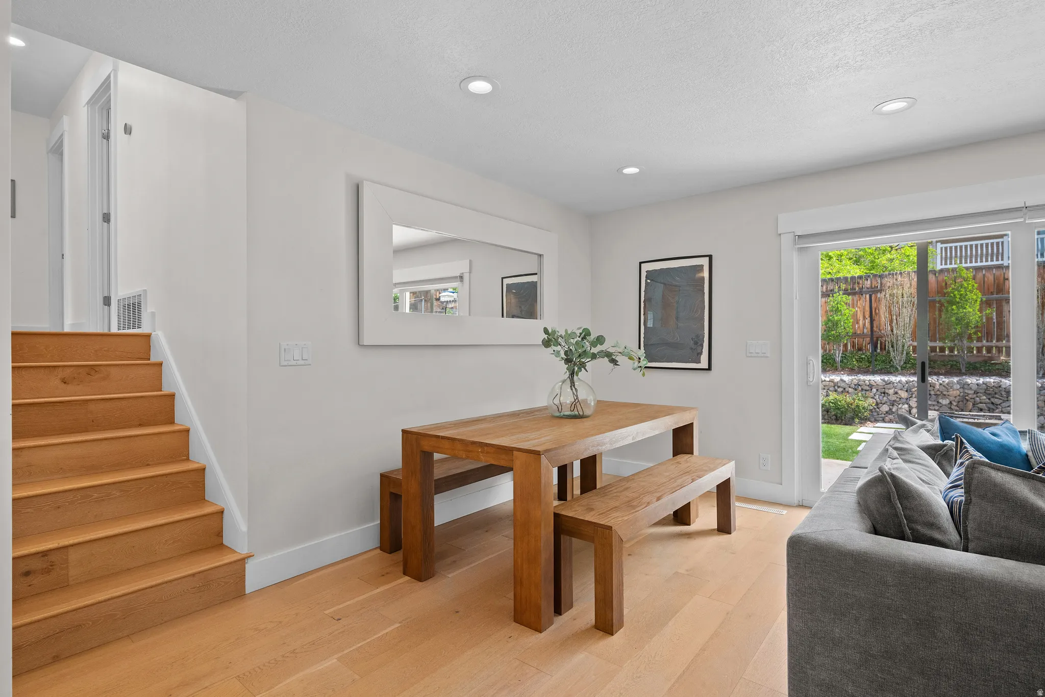 Dining area featuring light wood-style flooring, recessed lighting, and a textured ceiling
