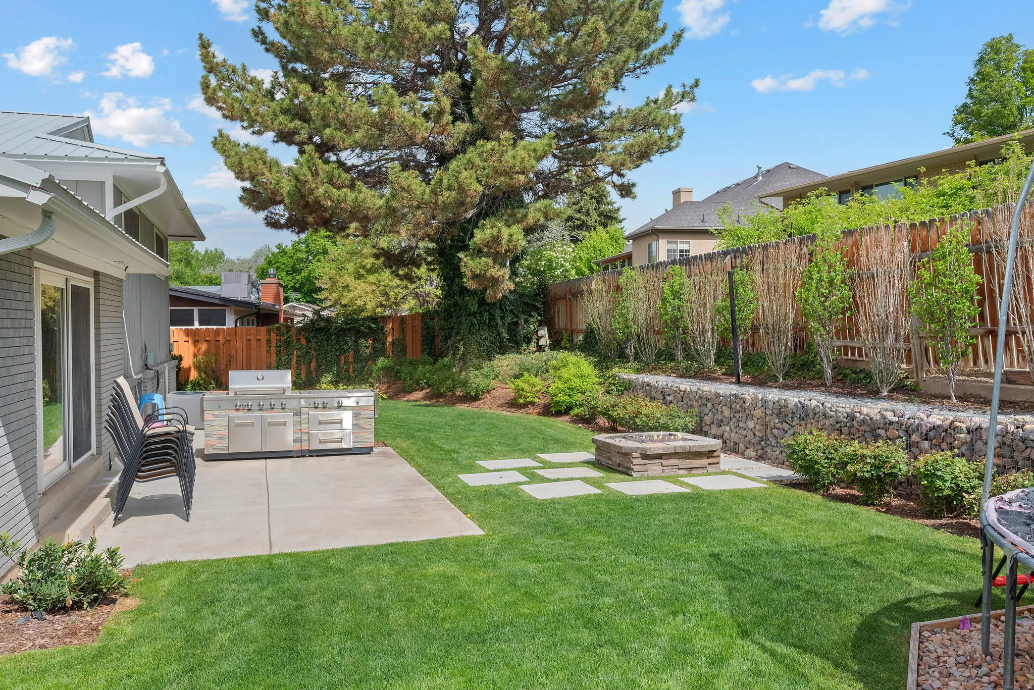 Fenced backyard with a patio area, area for grilling, and a fire pit