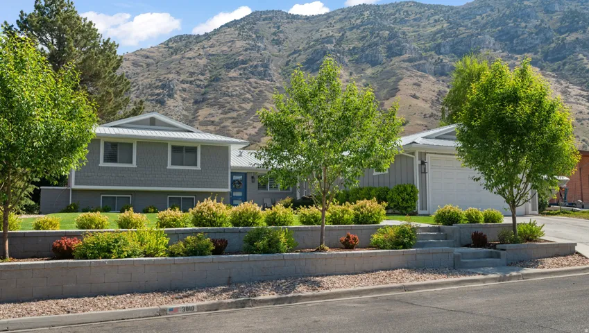 View of front of property with a garage, a mountain view, concrete driveway, and board and batten siding