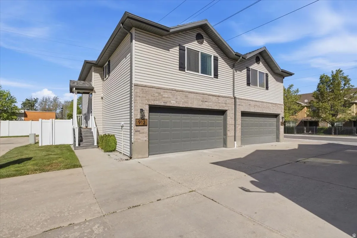 View of property exterior featuring driveway, a garage, and brick siding