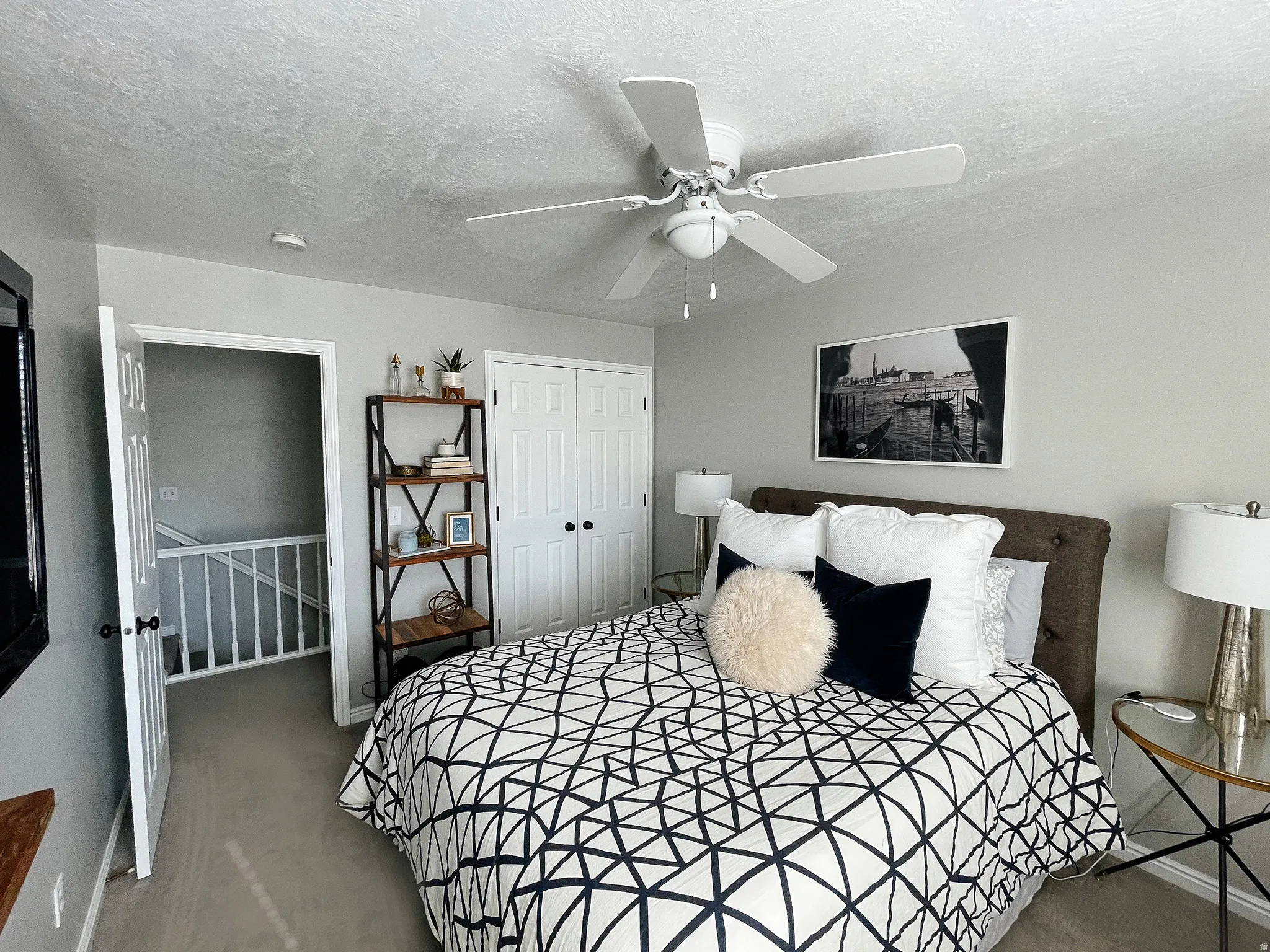 Bedroom featuring a closet, light colored carpet, a textured ceiling, and ceiling fan