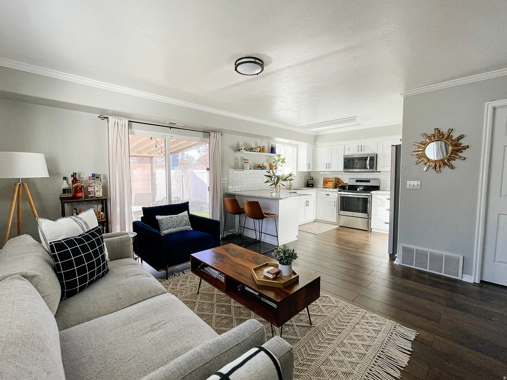Living area with dark wood-style floors and ornamental molding