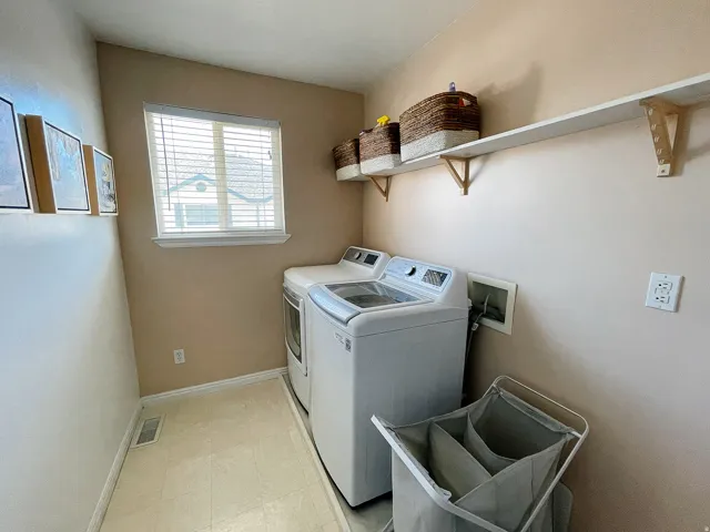 Laundry room featuring washer and dryer and light flooring