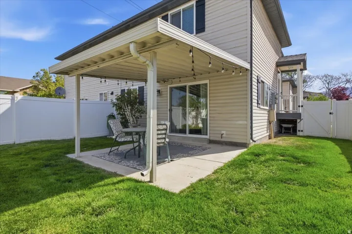 Fenced backyard with a gate and a patio area