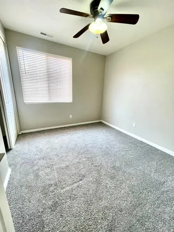 Empty room featuring carpet floors and ceiling fan
