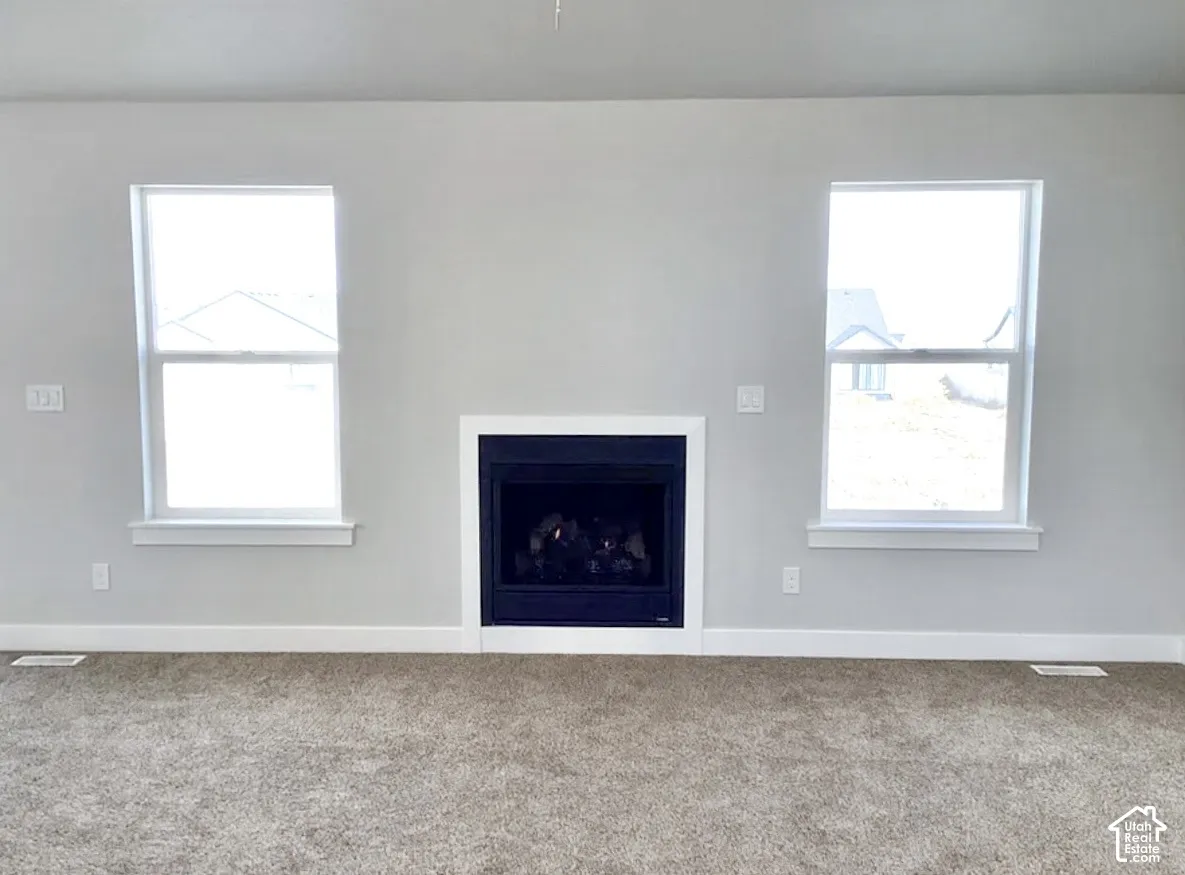 Recessed fireplace with white surround, light gray walls, and carpet flooring