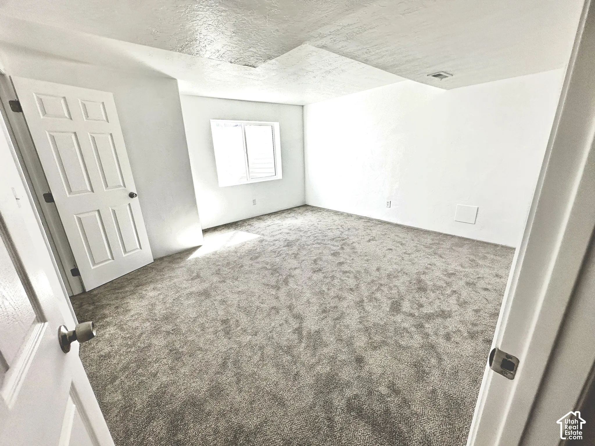 Wall-to-wall carpeting with light-toned walls and ceiling