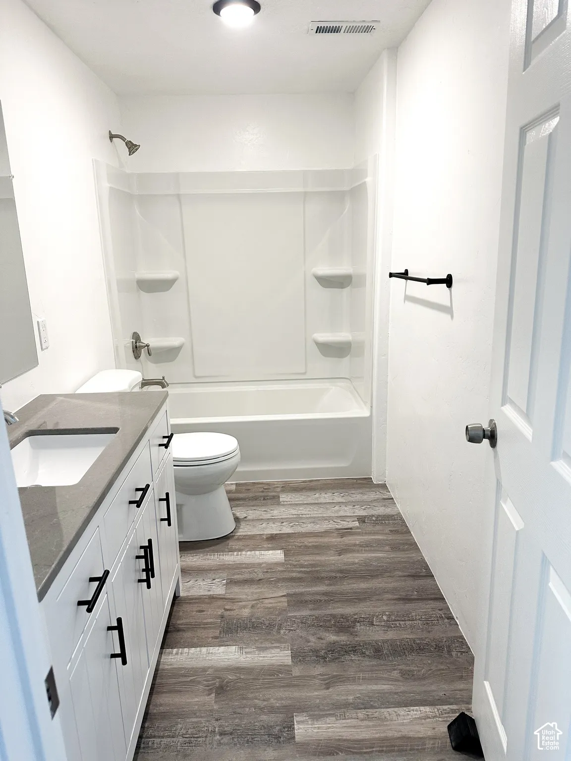 White vanity with matte black hardware, integrated sink, and gray countertop