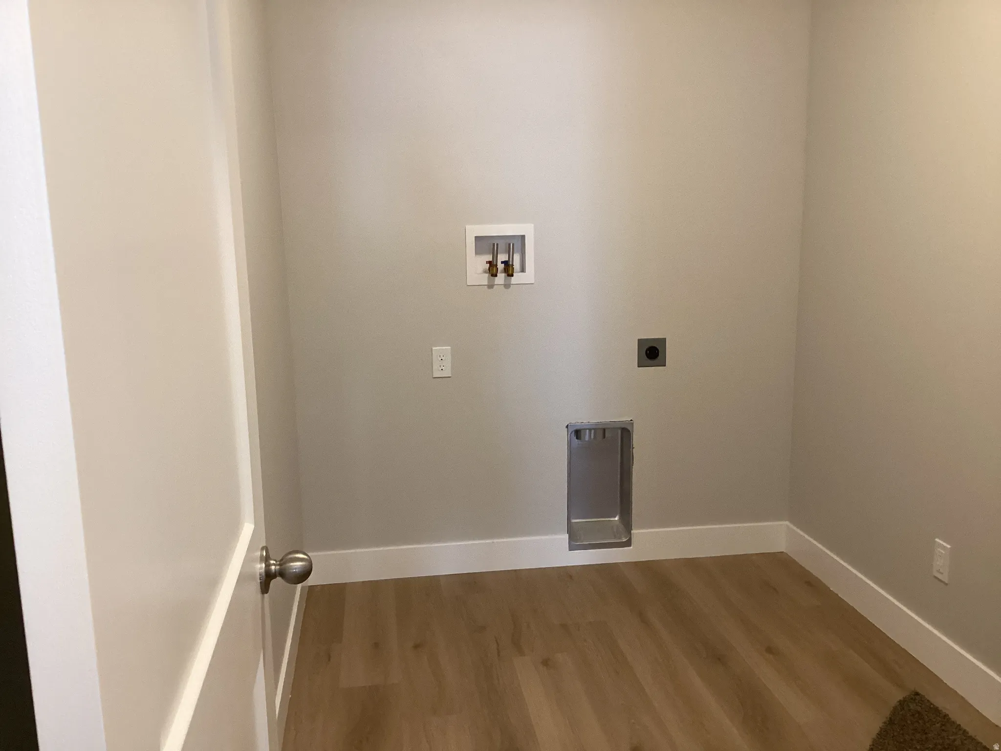Laundry room featuring light wood-style flooring, washer hookup, and hookup for an electric dryer