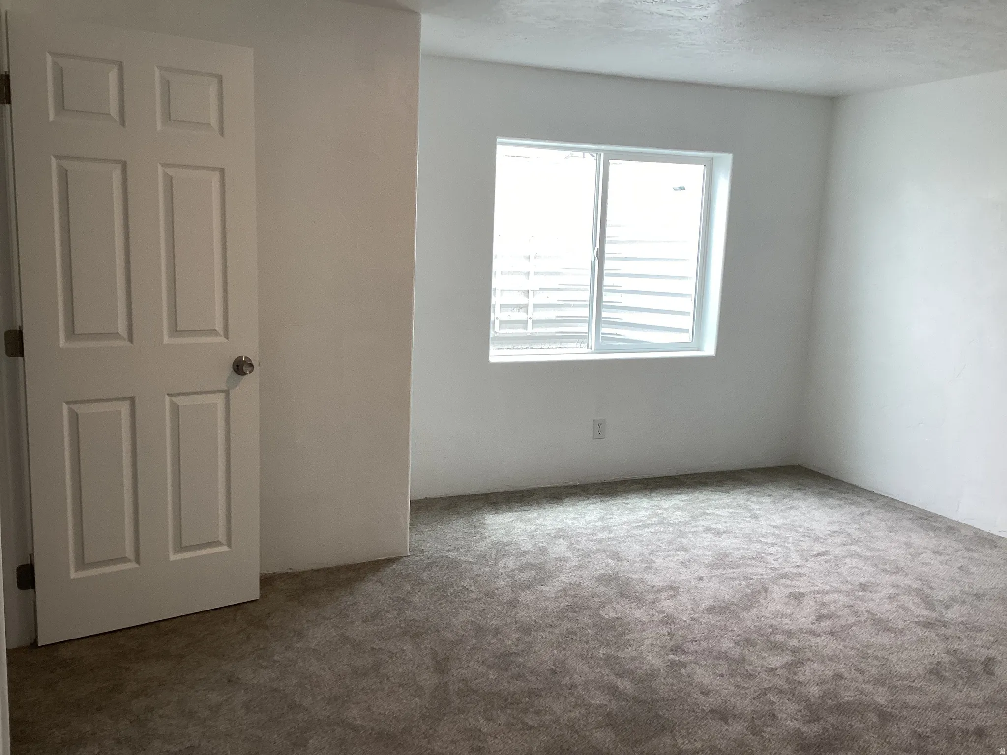 Spare room featuring carpet flooring and a textured ceiling