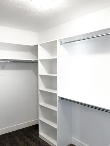 Built-in shelving and multiple chrome hanging rods provide extensive storage