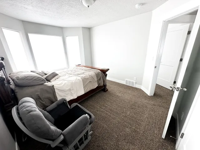 Wall-to-wall carpeting with light-colored walls and multiple windows