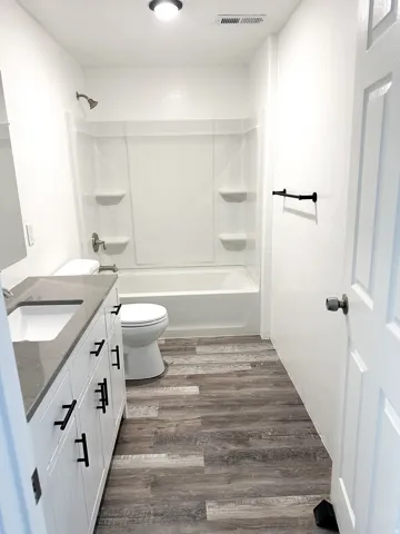 White vanity with matte black hardware, integrated sink, and gray countertop