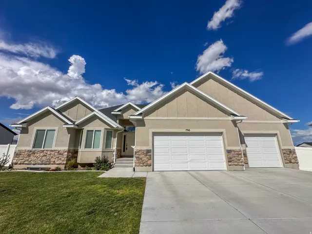 Contemporary facade featuring stone accents, stucco finish, and a concrete driveway
