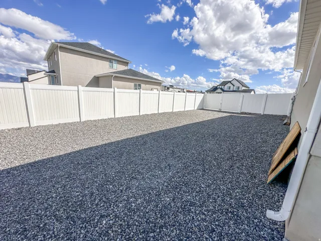 Fenced yard featuring a gravel surface