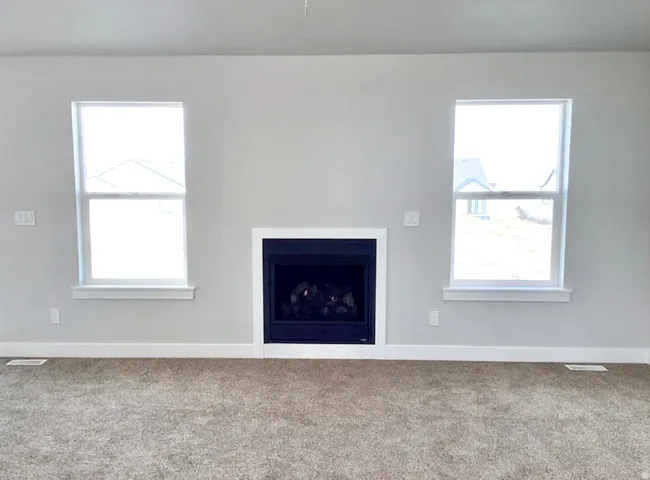 Recessed fireplace with white surround, light gray walls, and carpet flooring