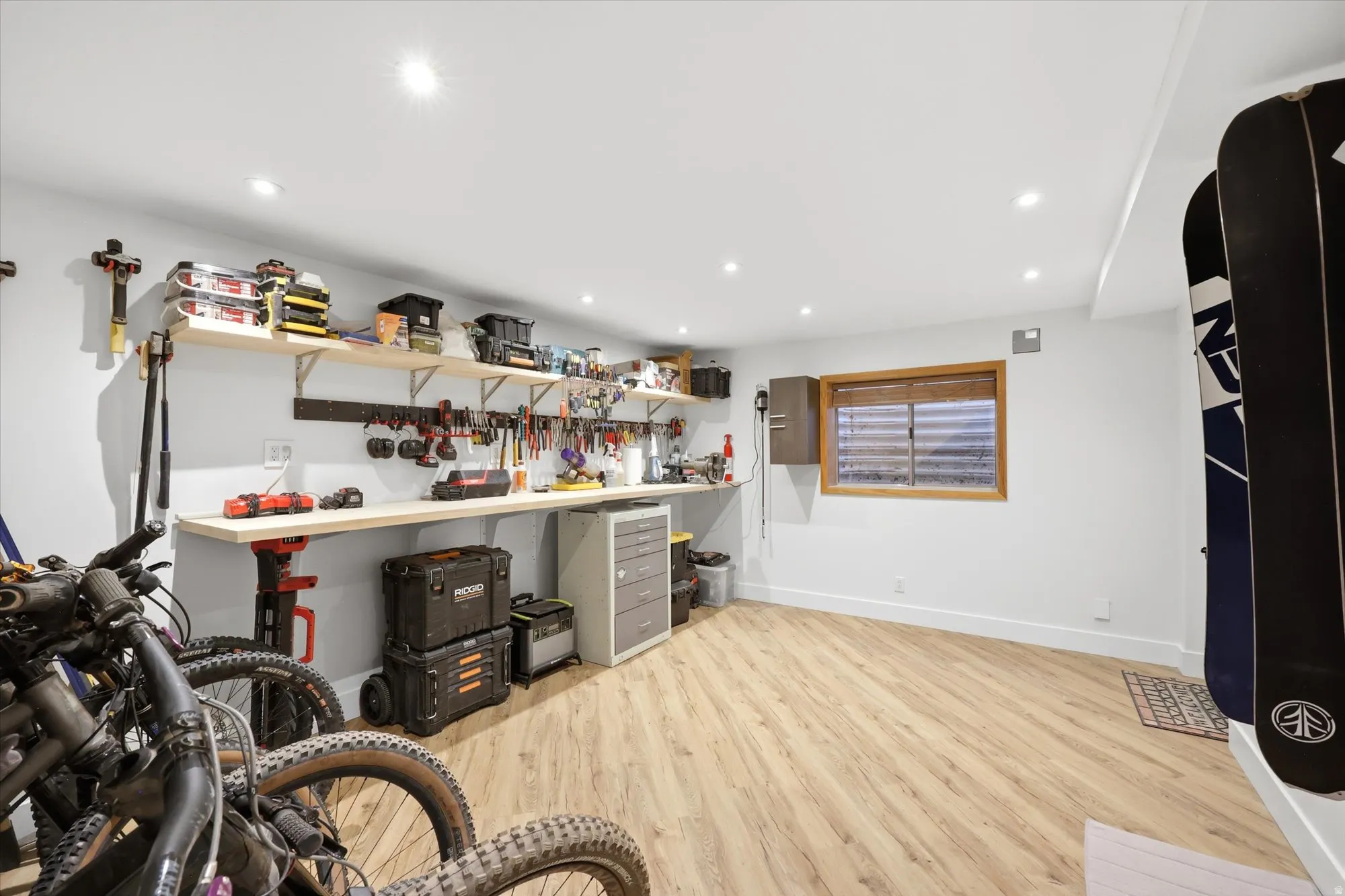 Misc room featuring light wood-style floors, recessed lighting, and a workshop area