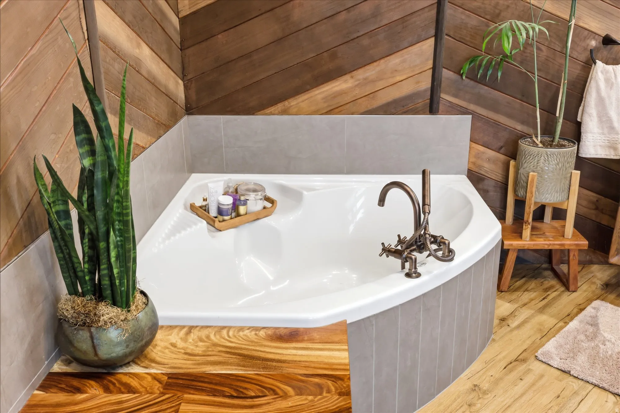 Full bath with a garden tub, hardwood / wood-style floors, and wooden walls
