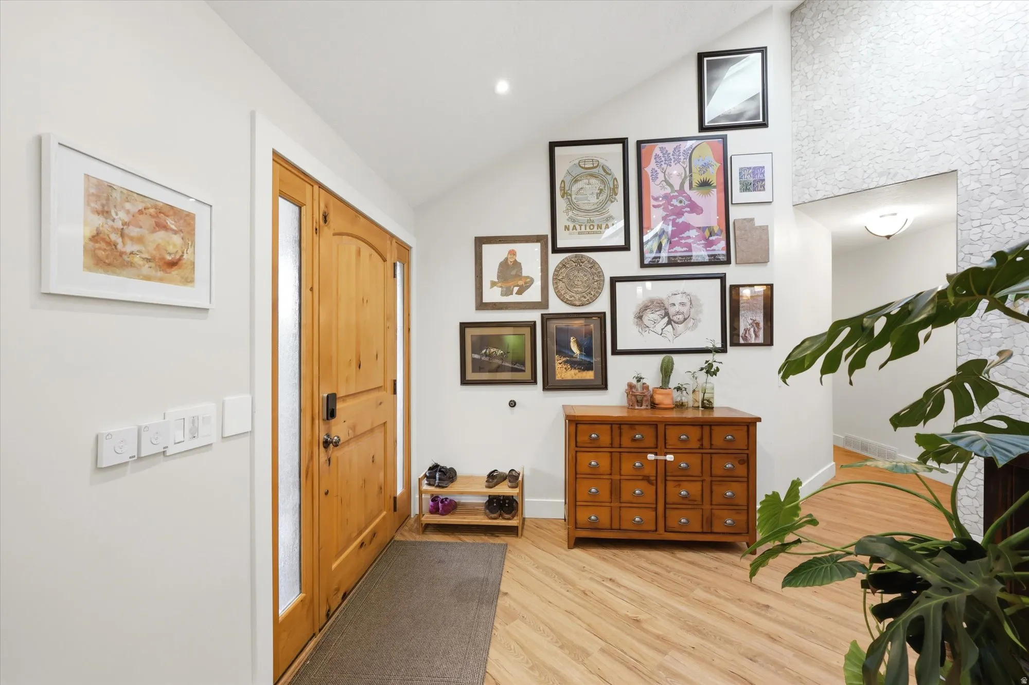 Entrance foyer featuring vaulted ceiling, light wood-style floors, and recessed lighting