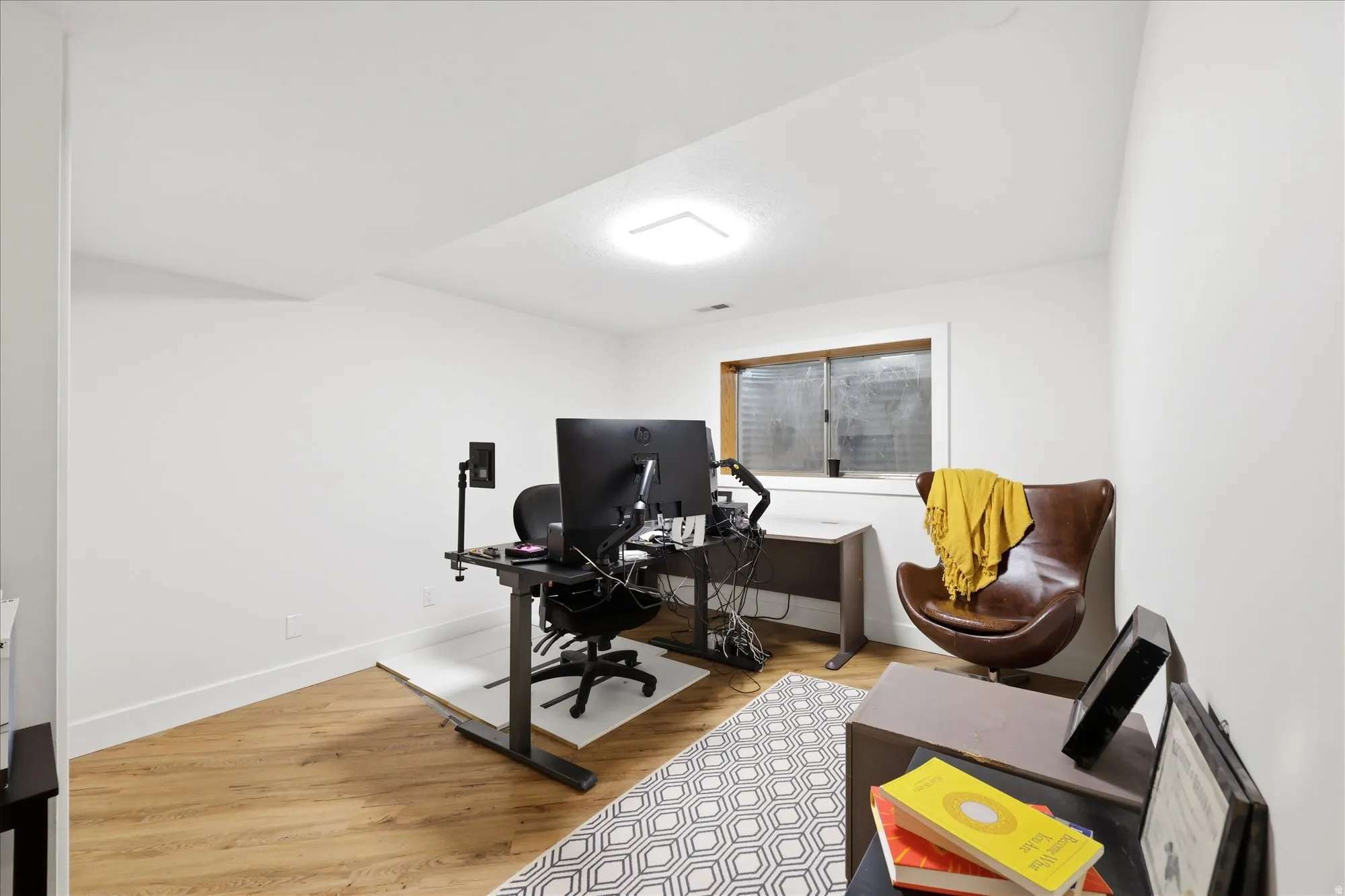 Office with light wood-style flooring and baseboards