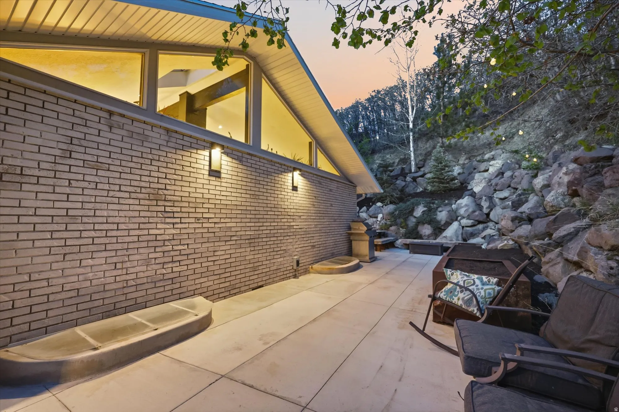 Property exterior at dusk featuring brick siding and a patio