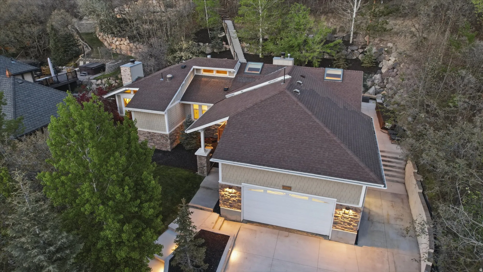 View of subject property featuring a tree filled landscape