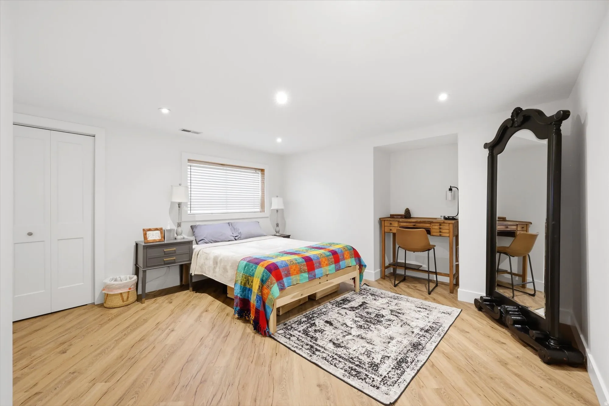 Bedroom with light wood finished floors, recessed lighting, and a closet