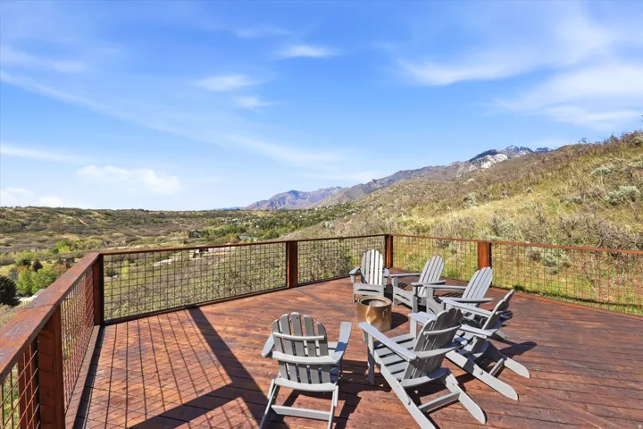 Wooden terrace featuring a mountain view and a fire pit