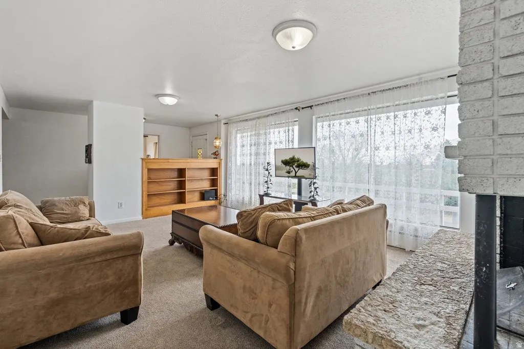 Carpeted living room with a brick fireplace
