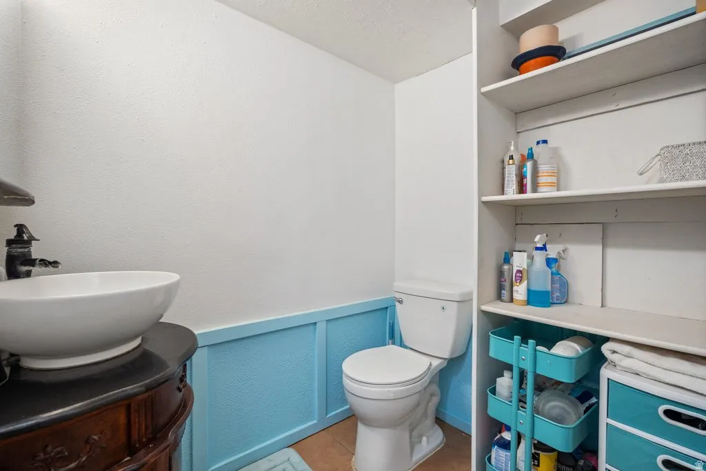 Bathroom with vanity, a wainscoted wall, and a decorative wall