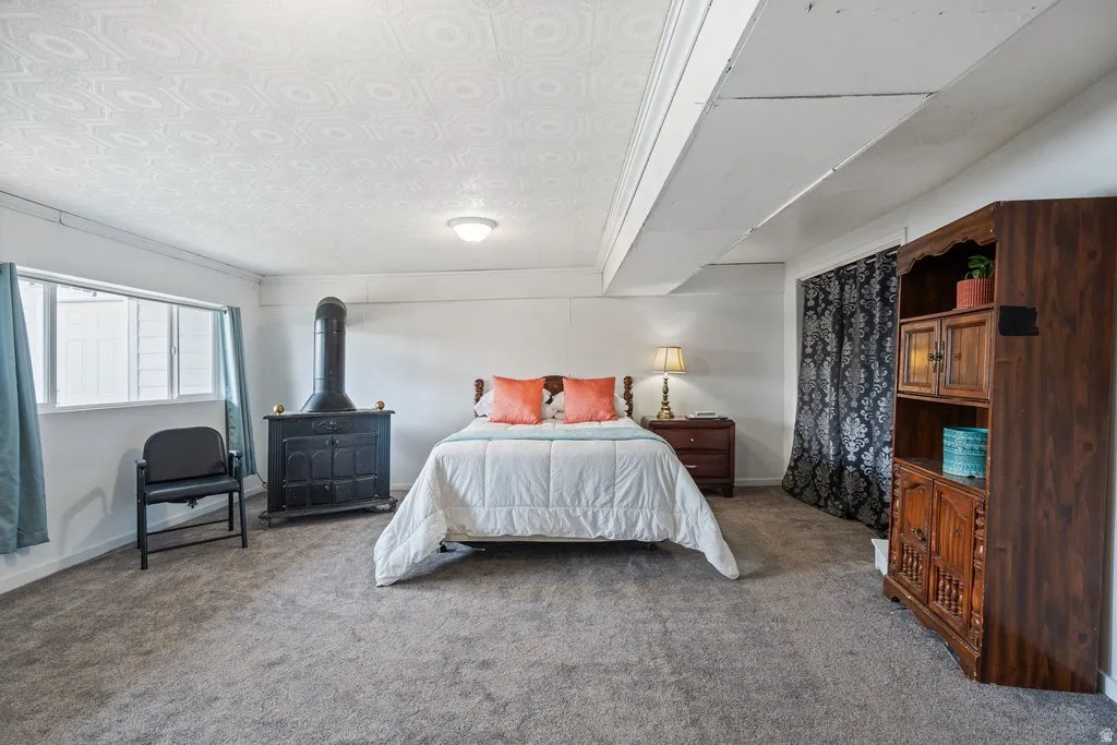 Bedroom featuring carpet floors and a wood stove
