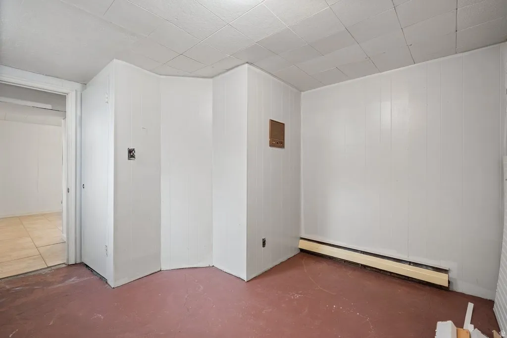 Unfurnished room with a baseboard radiator and concrete flooring