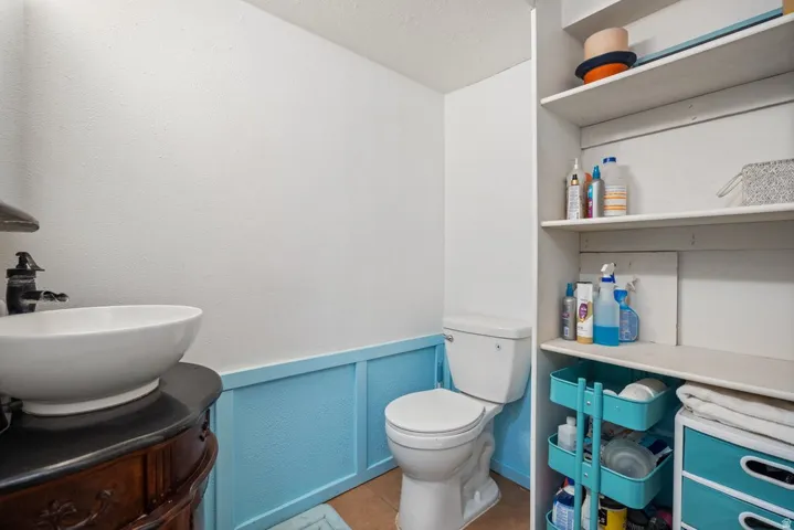 Bathroom with vanity, a wainscoted wall, and a decorative wall