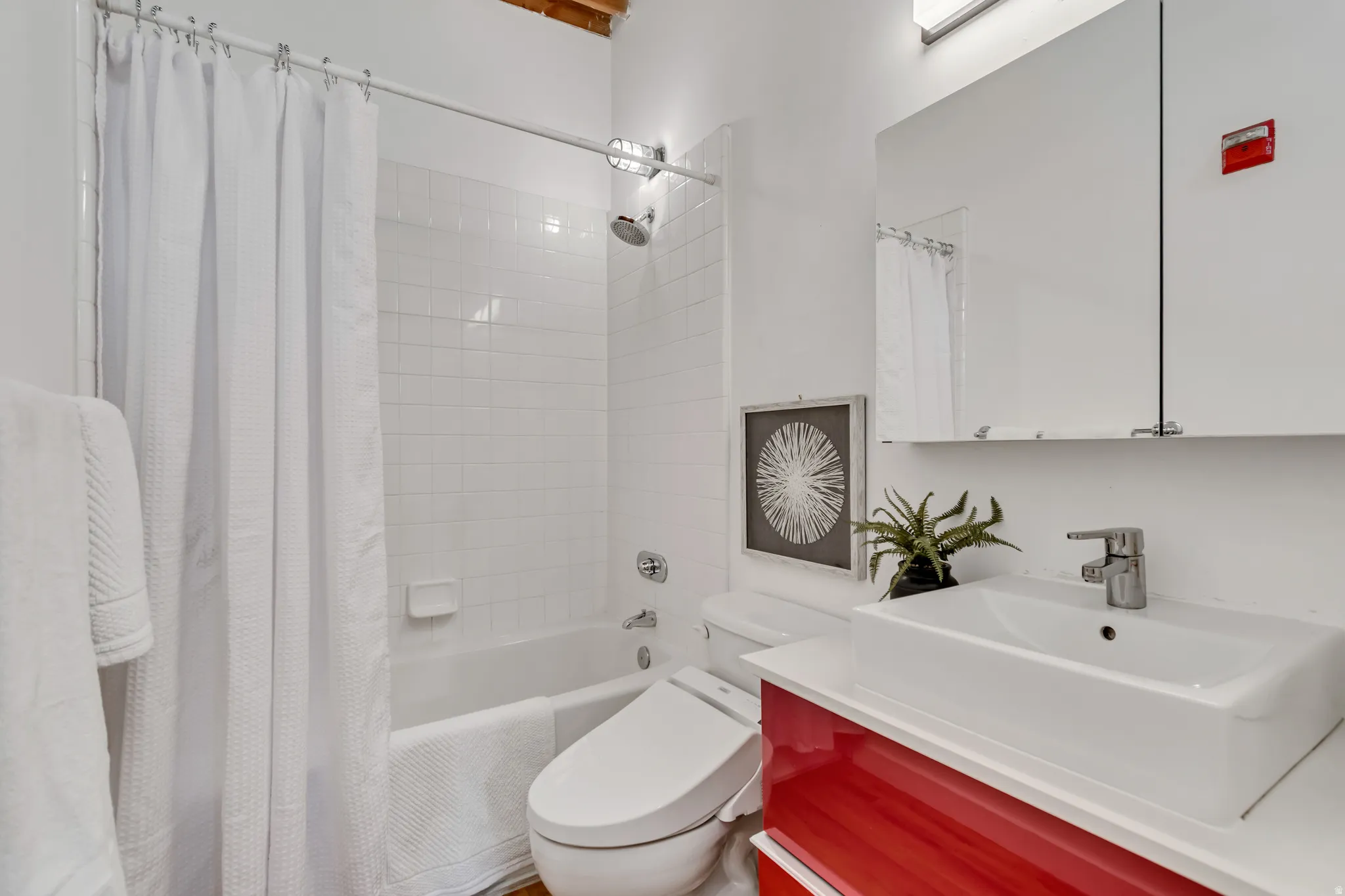 Bathroom featuring vanity and shower / bath combination with curtain