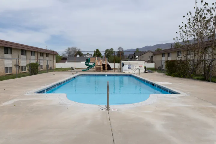 Community pool featuring a patio and a residential view