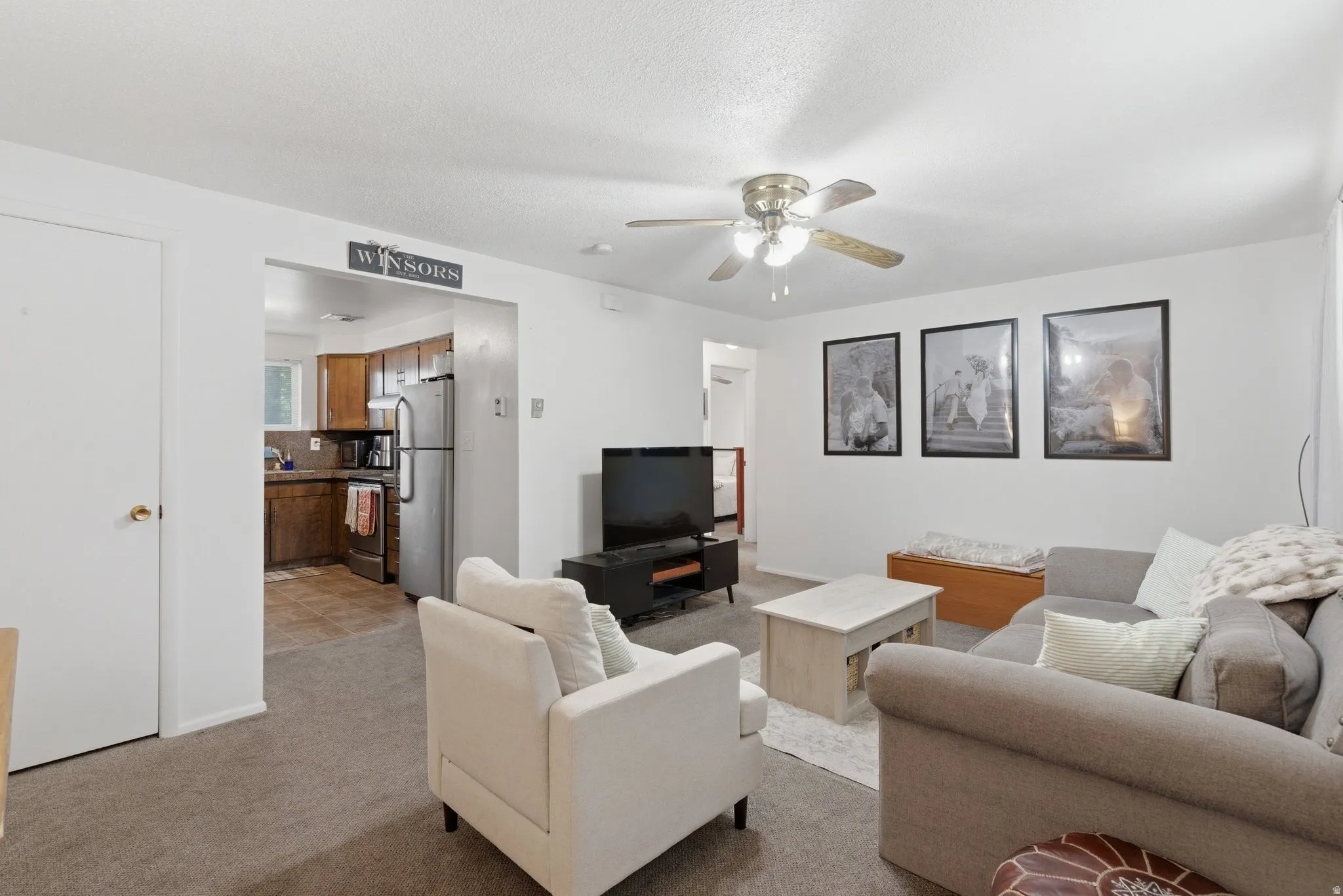 Living room featuring a ceiling fan and light colored carpet