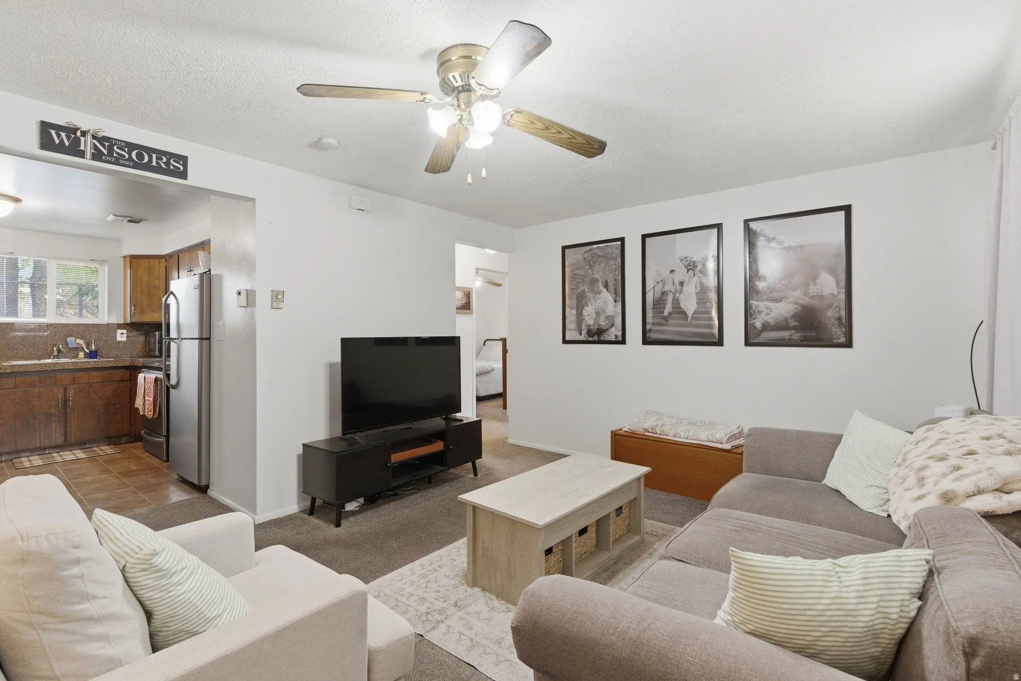 Living area with a ceiling fan and carpet floors