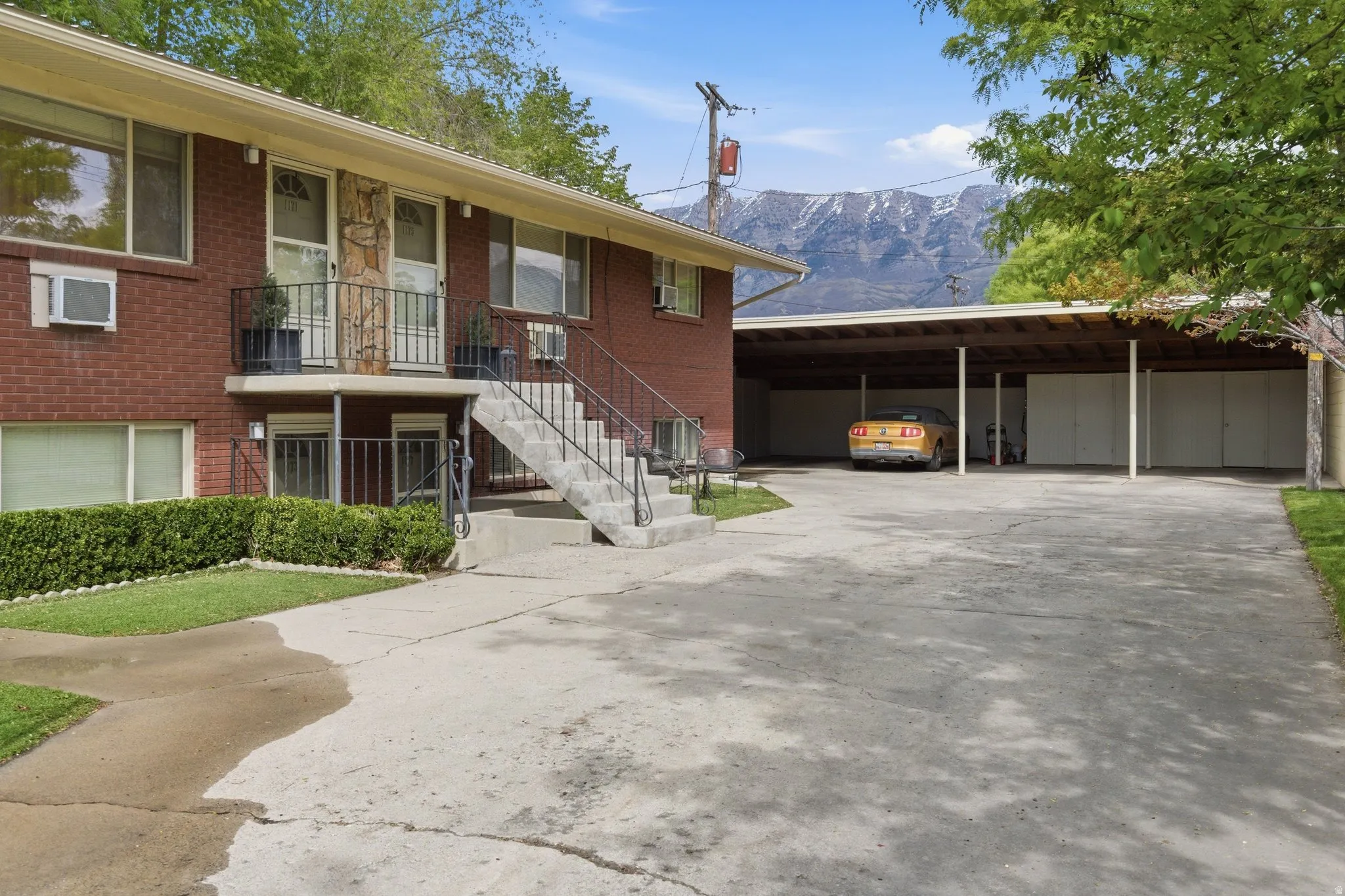 View of front of home with brick siding, concrete driveway, and a mountain view