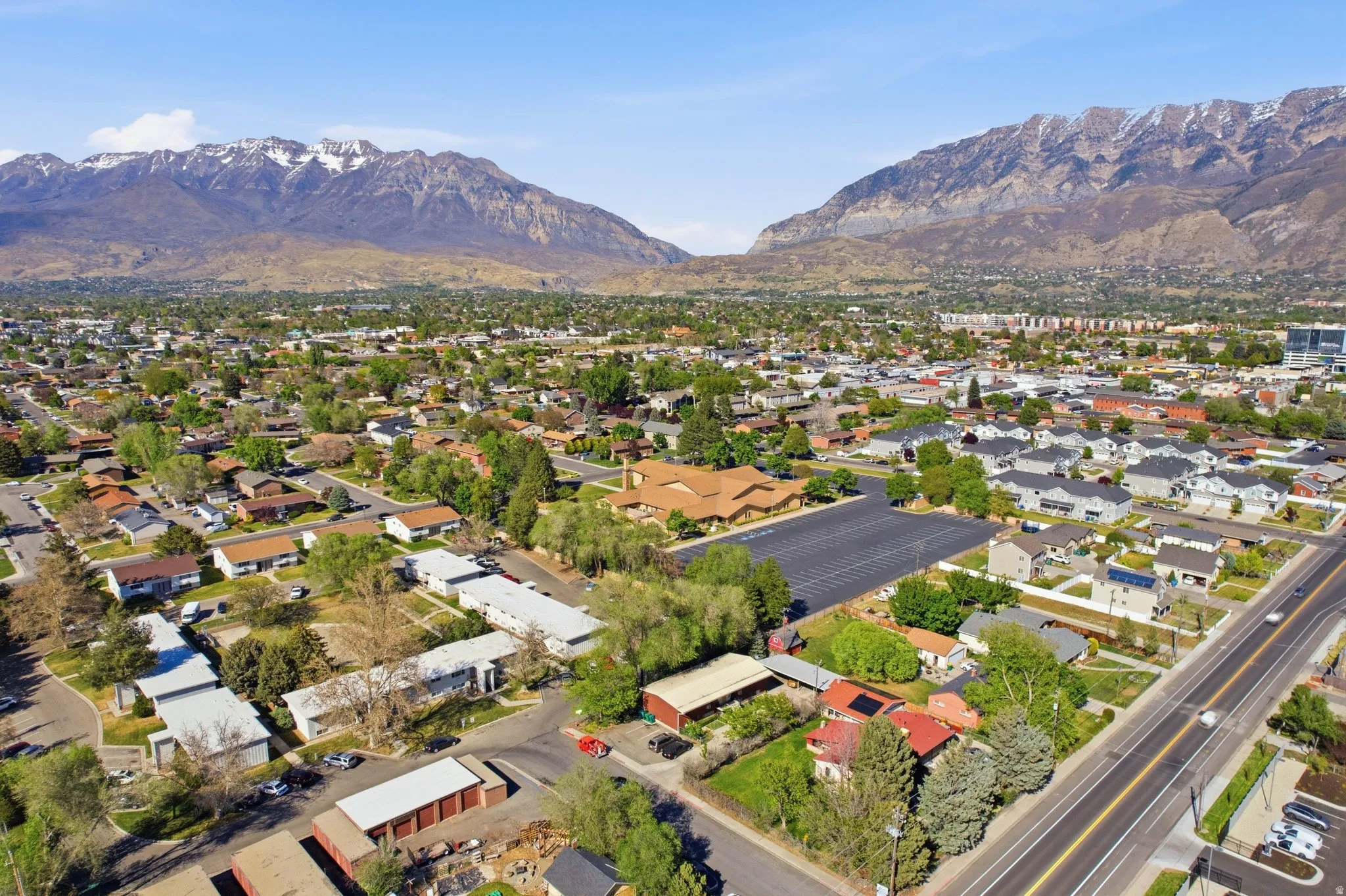 Aerial view of property and surrounding area with mountains and nearby suburban area