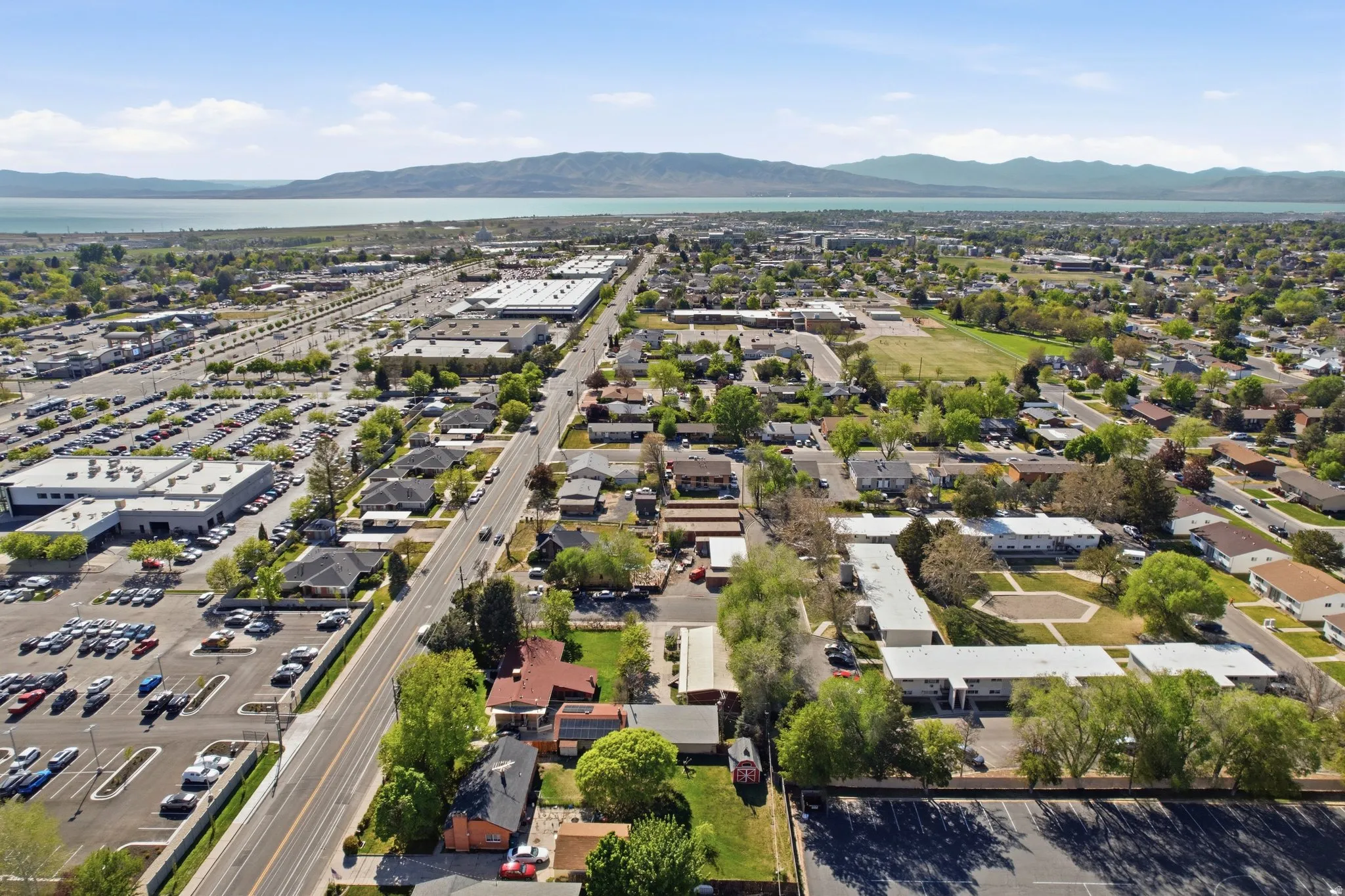 Aerial view of property and surrounding area featuring a mountain backdrop