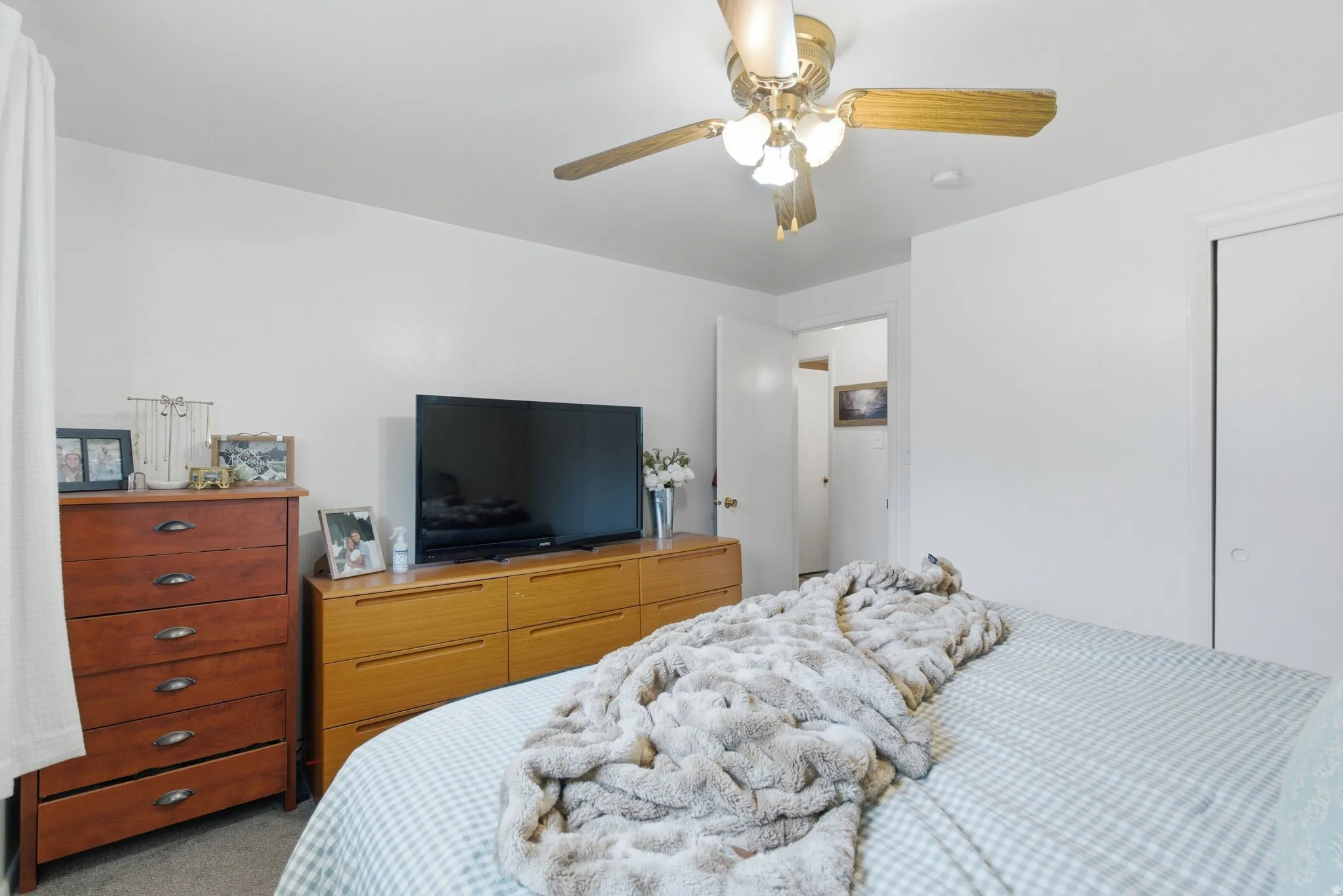 Bedroom with light carpet and a ceiling fan