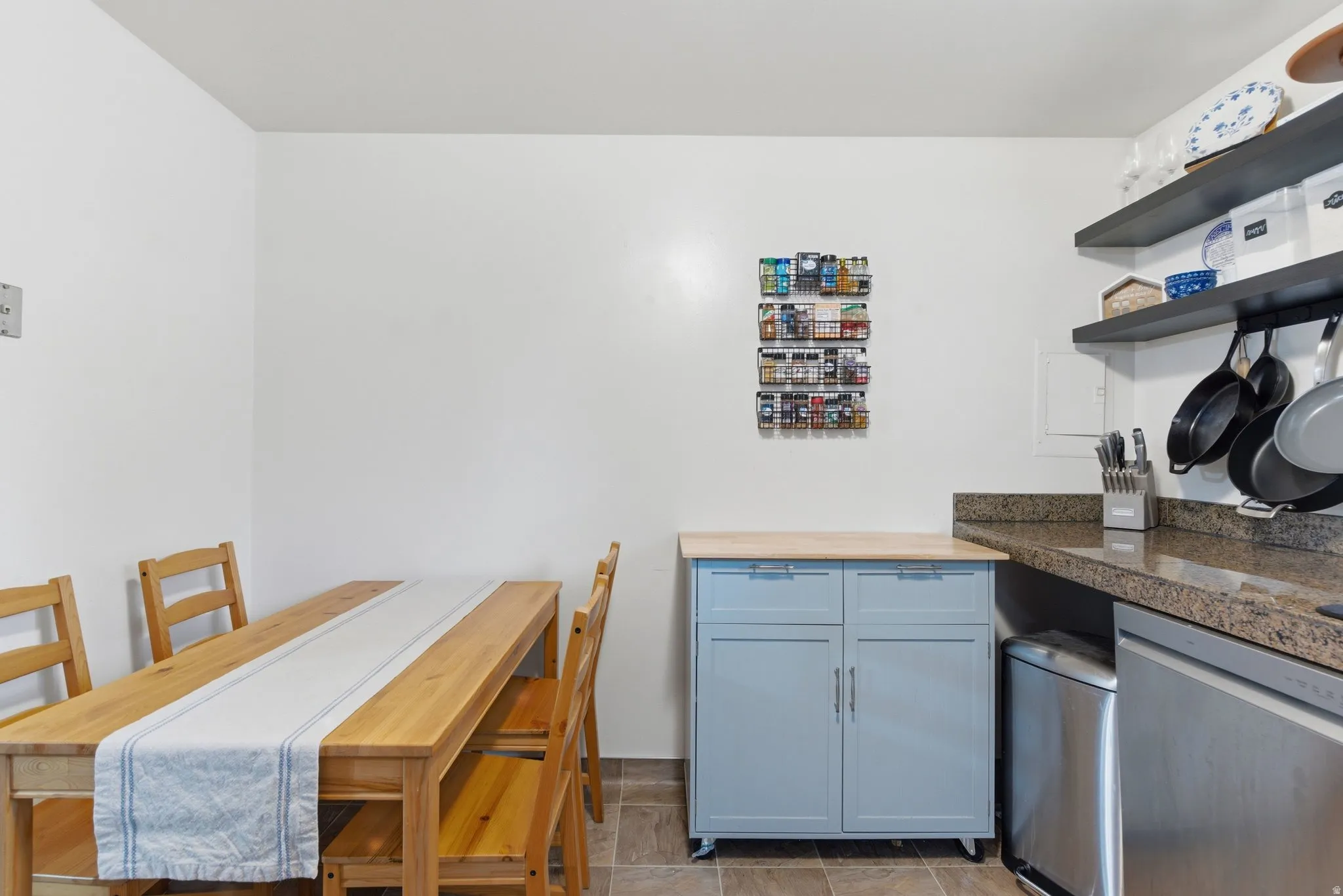 Kitchen featuring stainless steel dishwasher, open shelves, and butcher block countertops
