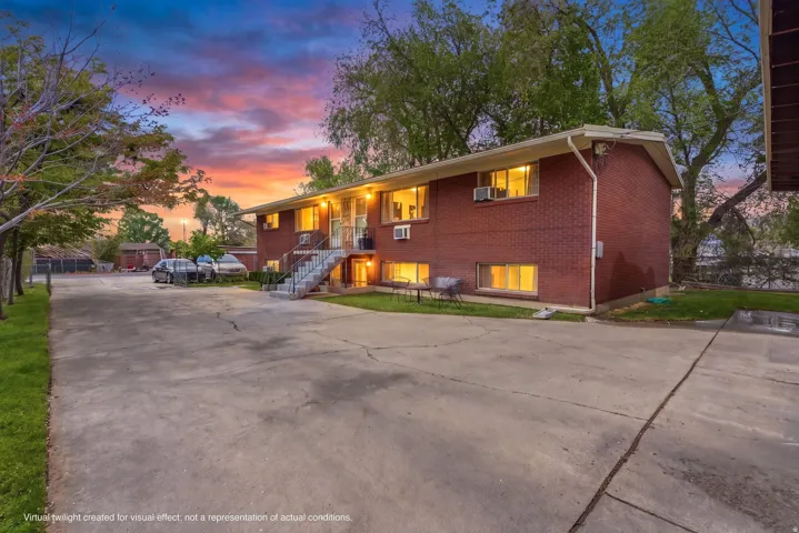 Bi-level home with brick siding, driveway, and a patio area