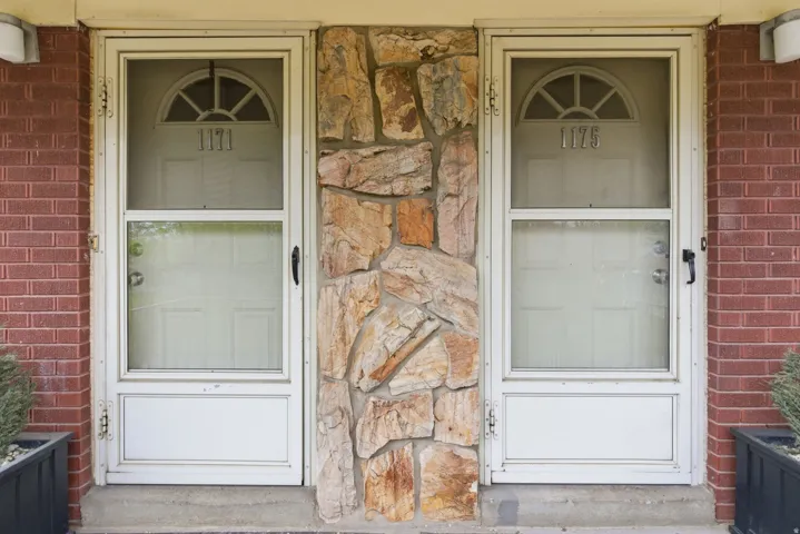 View of exterior entry with stone siding and brick siding