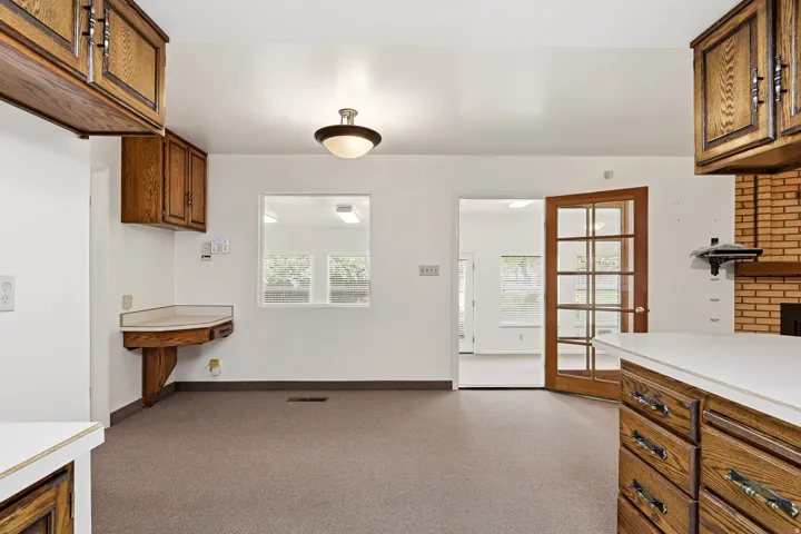 Kitchen featuring wood finish cabinetry, light countertops, and healthy amount of natural light