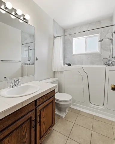 Bathroom with vanity, light tile patterned floors, and shower / tub combo
