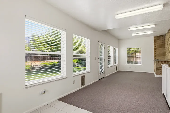 Doorway with a textured ceiling, tile patterned flooring, and carpet