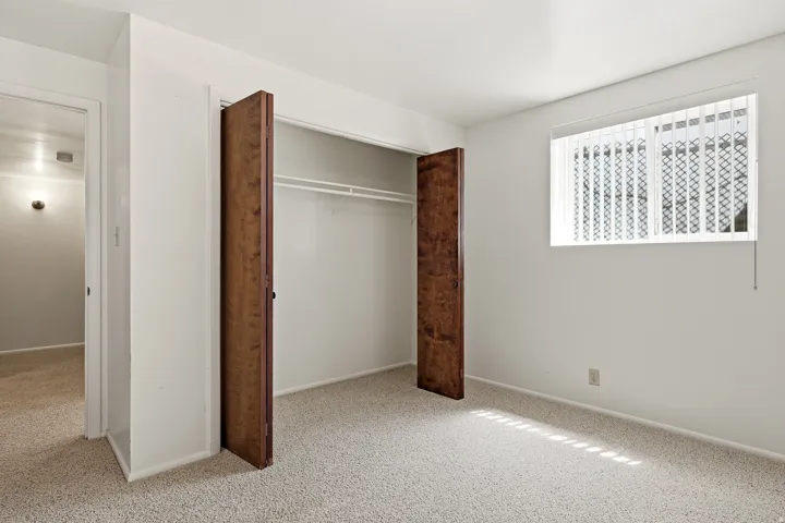 Unfurnished bedroom with light colored carpet and a closet